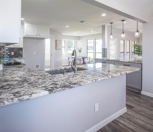 102 Camino Real W, Wylie, TX 75098 - kitchen featuring a peninsula, dark wood-style flooring, light stone counters, backsplash, and recessed lighting