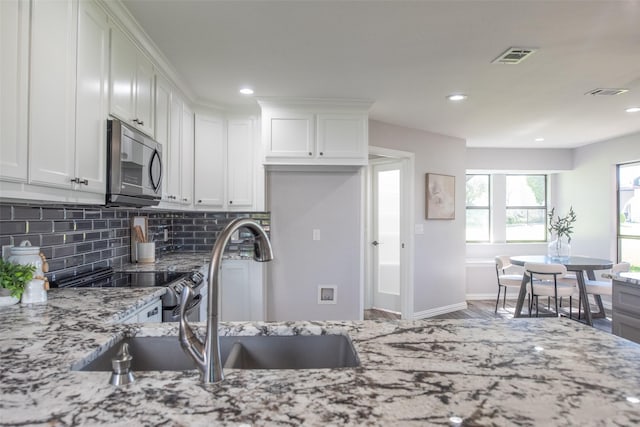 102 Camino Real W, Wylie, TX 75098 - kitchen featuring backsplash, a sink, light stone countertops, white cabinets, and recessed lighting