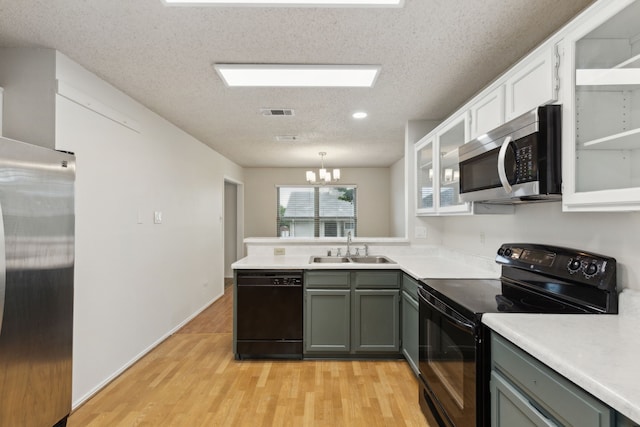 3516 Napolean Ct, Plano, TX 75023 - kitchen featuring black appliances, a sink, a textured ceiling, a peninsula, and light wood finished floors