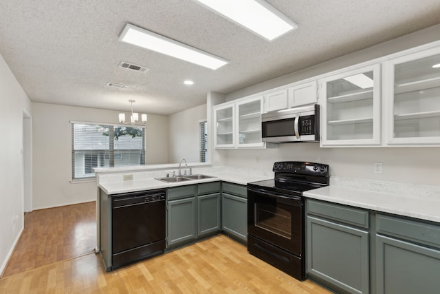 3516 Napolean Ct, Plano, TX 75023 - kitchen featuring black appliances, a sink, a peninsula, light countertops, and a textured ceiling