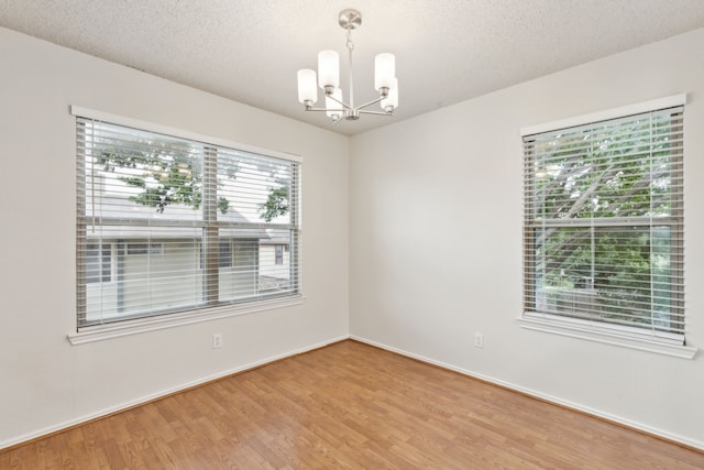3516 Napolean Ct, Plano, TX 75023 - spare room with a chandelier, wood finished floors, a textured ceiling, and baseboards
