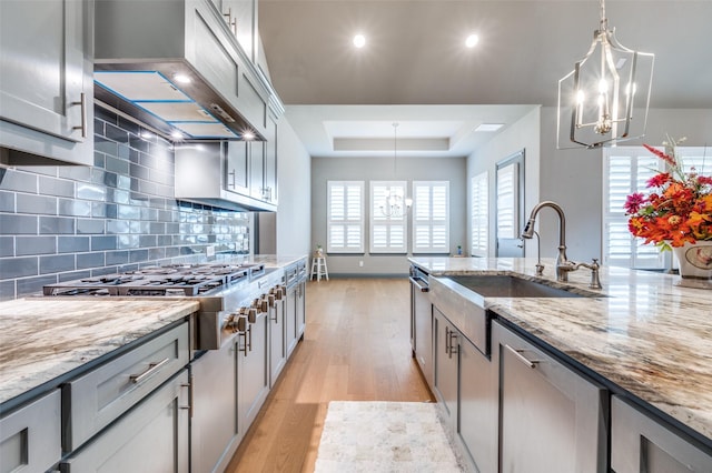 1930 Inwood Ln, Prosper, TX 75078 - kitchen featuring a chandelier, a raised ceiling, light wood finished floors, backsplash, and recessed lighting
