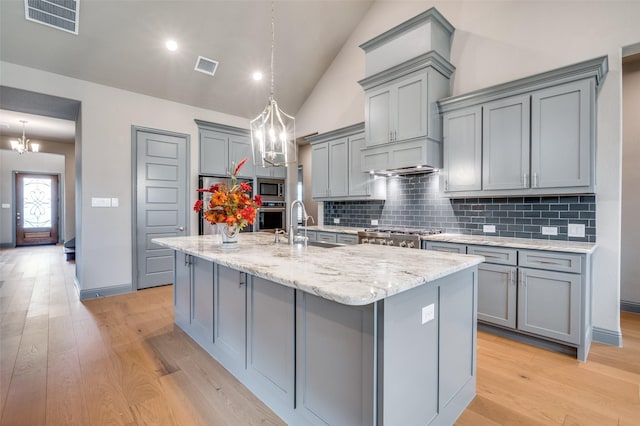 1930 Inwood Ln, Prosper, TX 75078 - kitchen featuring gray cabinetry, a chandelier, appliances with stainless steel finishes, a sink, and a center island with sink