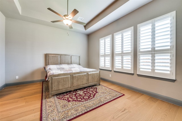1930 Inwood Ln, Prosper, TX 75078 - bedroom with light wood-type flooring, a tray ceiling, and baseboards