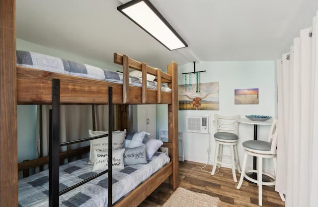 bedroom with lofted ceiling and wood finished floors