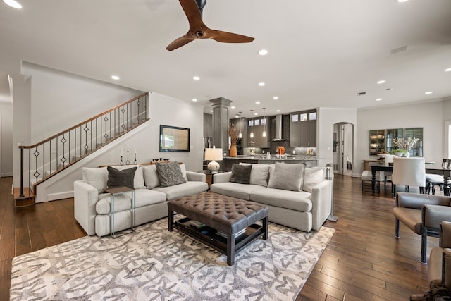 living room with stairs, ceiling fan, recessed lighting, ornamental molding, and dark wood finished floors