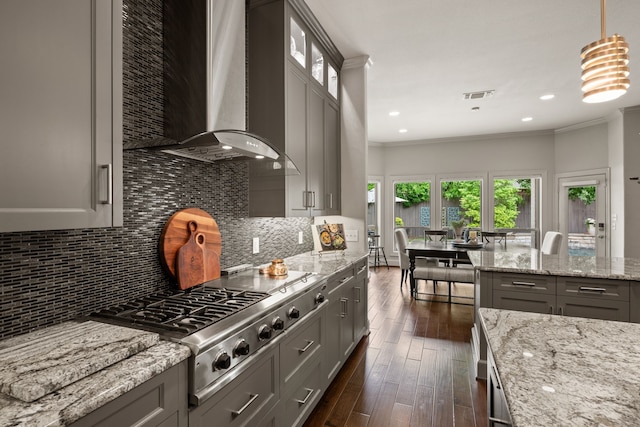 kitchen featuring wall chimney range hood, gray cabinets, stainless steel gas cooktop, light stone counters, and dark wood-style flooring