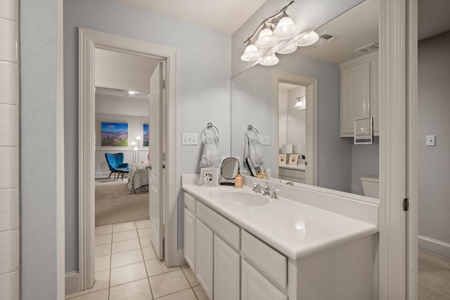 bathroom featuring vanity, tile patterned flooring, baseboards, and toilet