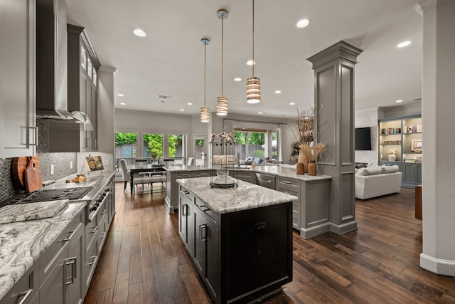 kitchen featuring wall chimney range hood, a center island, dark wood finished floors, decorative backsplash, and recessed lighting