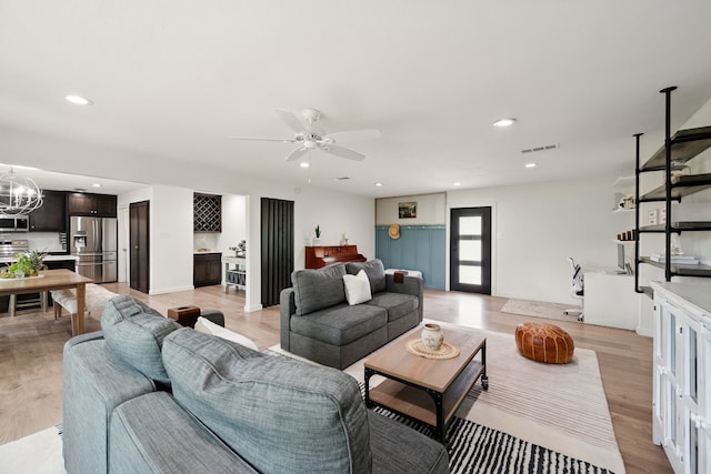 living room with light wood-style floors, a chandelier, a ceiling fan, and recessed lighting