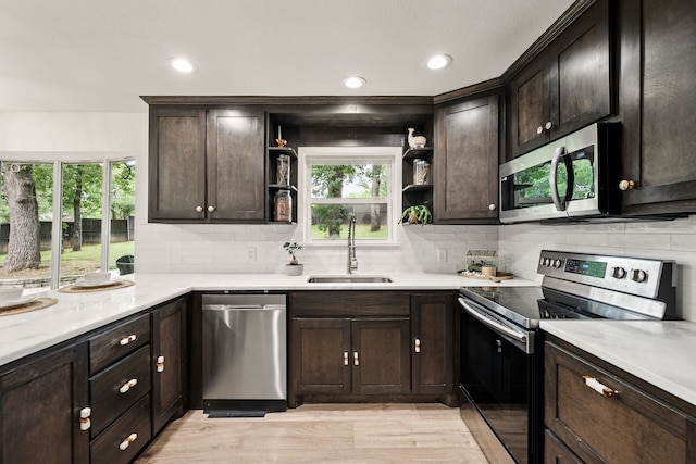 kitchen with appliances with stainless steel finishes, a sink, open shelves, decorative backsplash, and recessed lighting