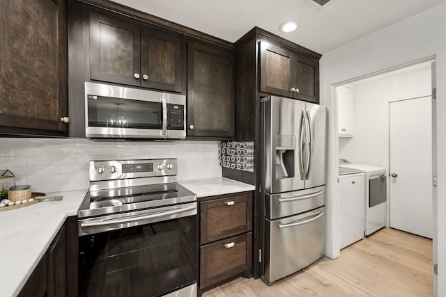 kitchen with stainless steel appliances, washer and dryer, light wood-type flooring, dark brown cabinetry, and recessed lighting