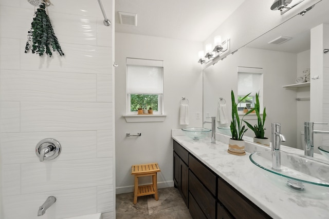 bathroom with double vanity, baseboards, and a shower