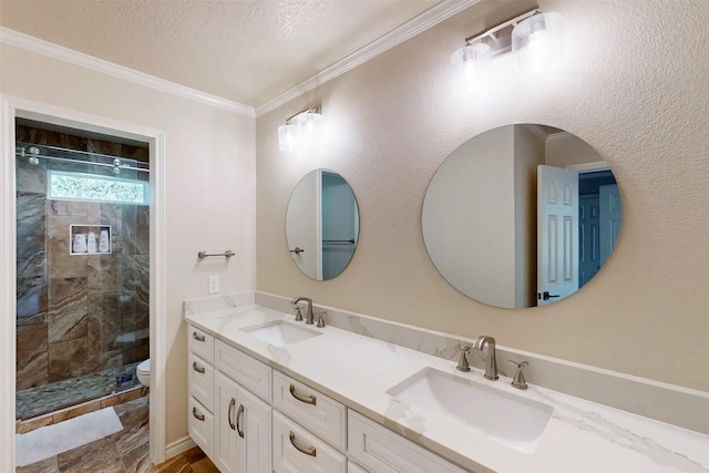 bathroom featuring toilet, tiled shower, a textured ceiling, double vanity, and crown molding