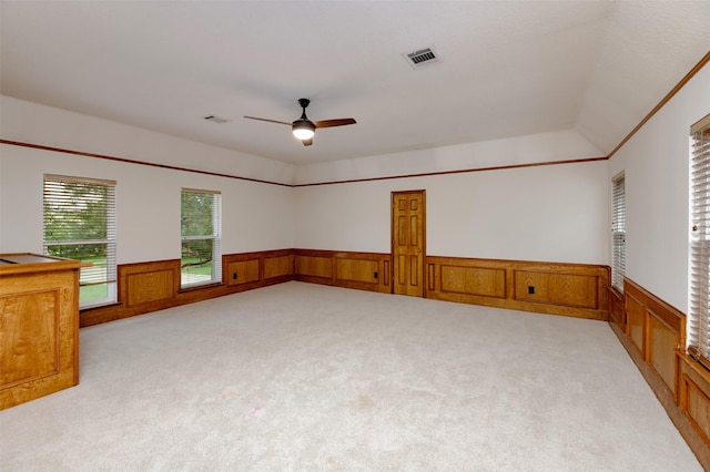 unfurnished room featuring wainscoting, light colored carpet, and a ceiling fan
