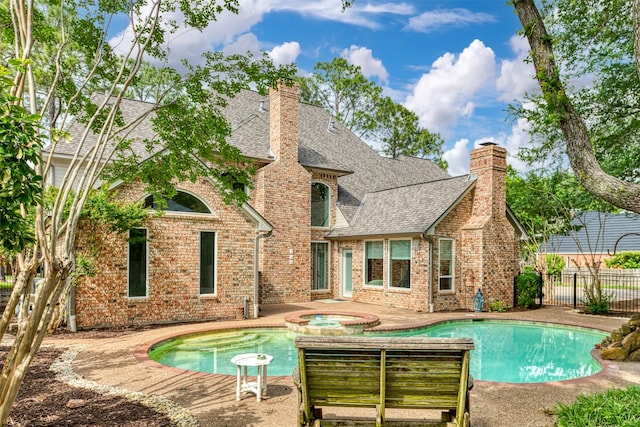 view of pool featuring fence, a patio area, and a pool with connected hot tub