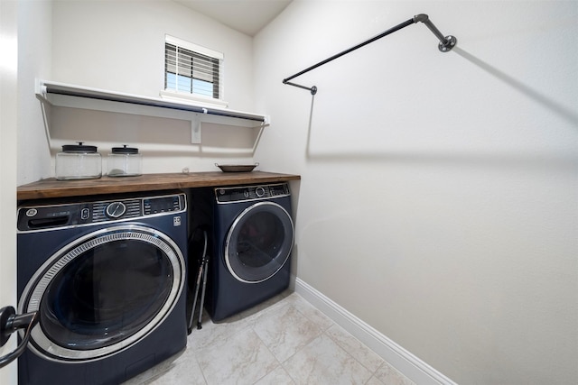 clothes washing area with washing machine and dryer and baseboards
