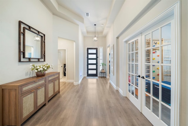 entrance foyer featuring light wood-style floors, french doors, and baseboards
