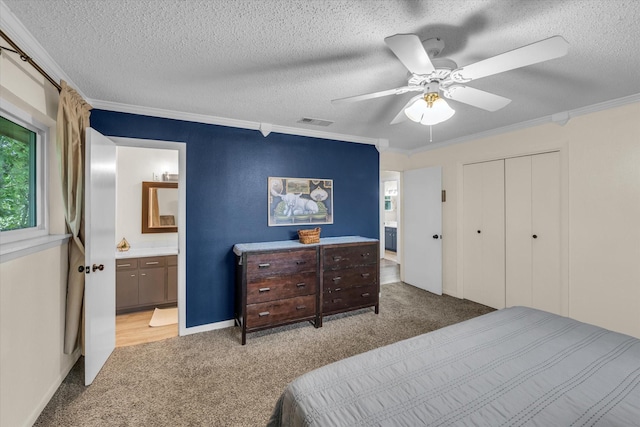 3601 Orchard Ln, Waco, TX 76705 - carpeted bedroom featuring crown molding, ensuite bath, a textured ceiling, a closet, and a ceiling fan