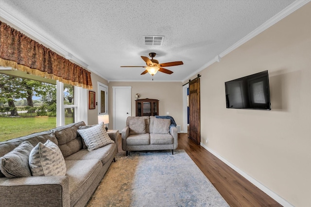3601 Orchard Ln, Waco, TX 76705 - living area featuring crown molding, a textured ceiling, wood finished floors, baseboards, and a ceiling fan
