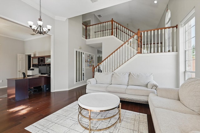 living area featuring wood finished floors, a chandelier, a towering ceiling, baseboards, and stairway