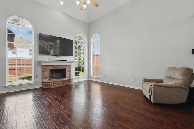 unfurnished living room featuring hardwood / wood-style floors, ceiling fan, plenty of natural light, and baseboards