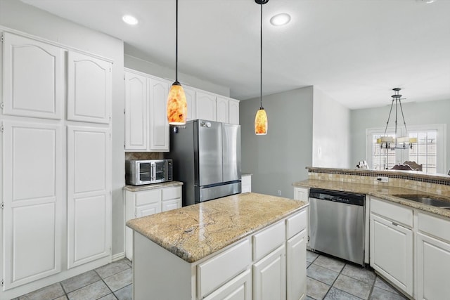 kitchen featuring stainless steel appliances, light tile patterned floors, a center island, white cabinetry, and light stone counters