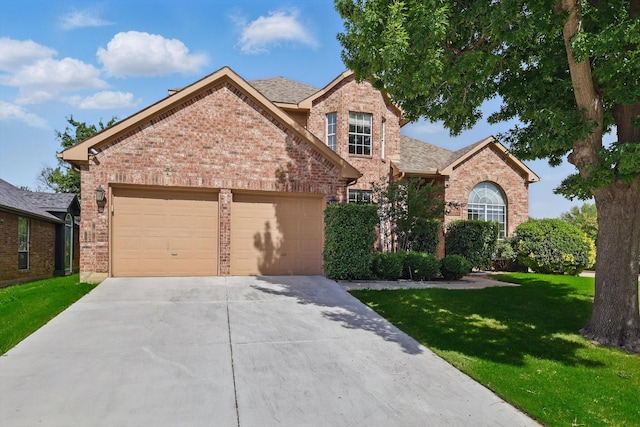 traditional home with brick siding, driveway, an attached garage, and a front yard