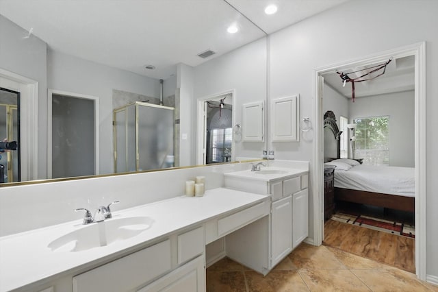 full bathroom with a stall shower, double vanity, recessed lighting, and ensuite bath