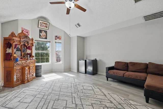 living room with a textured ceiling, ceiling fan, lofted ceiling, wood finished floors, and baseboards