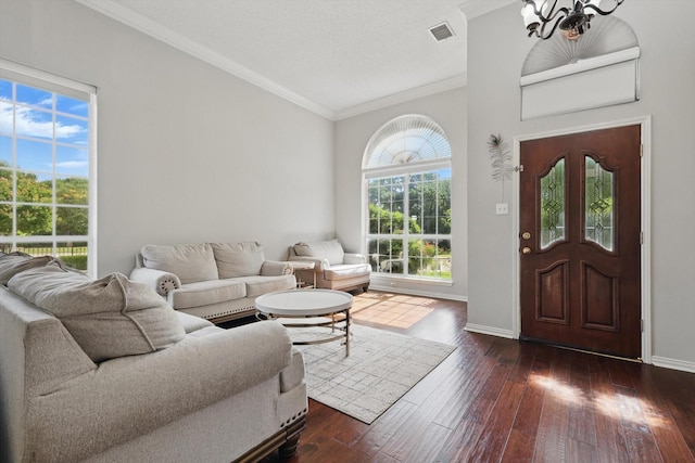 living area with a chandelier, dark wood-style flooring, ornamental molding, and baseboards