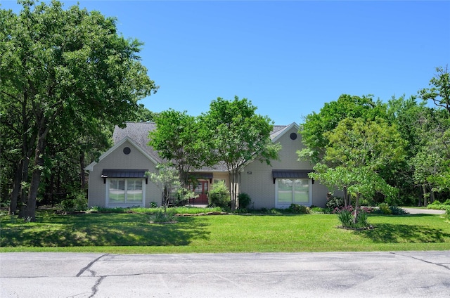 139 Shoshone Dr, Gainesville, TX 76240 - view of property hidden behind natural elements with a front lawn and brick siding