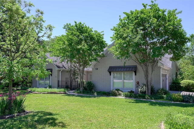 139 Shoshone Dr, Gainesville, TX 76240 - view of front facade featuring brick siding and a front lawn