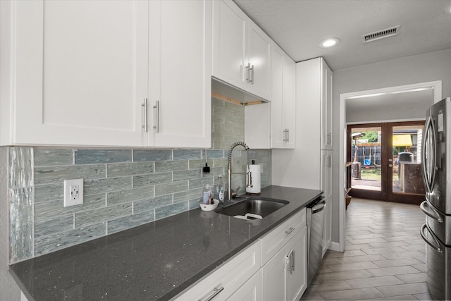 4677 Bracken Dr, Fort Worth, TX 76137 - kitchen featuring a sink, stainless steel appliances, french doors, decorative backsplash, and dark stone counters