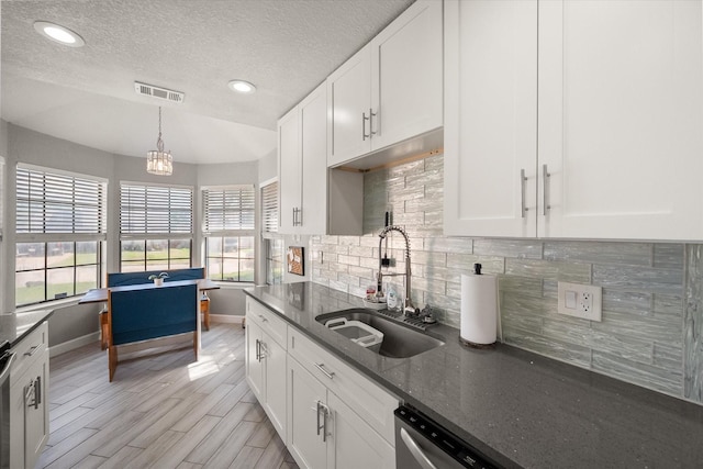 4677 Bracken Dr, Fort Worth, TX 76137 - kitchen with a sink, baseboards, backsplash, white cabinets, and dark stone counters