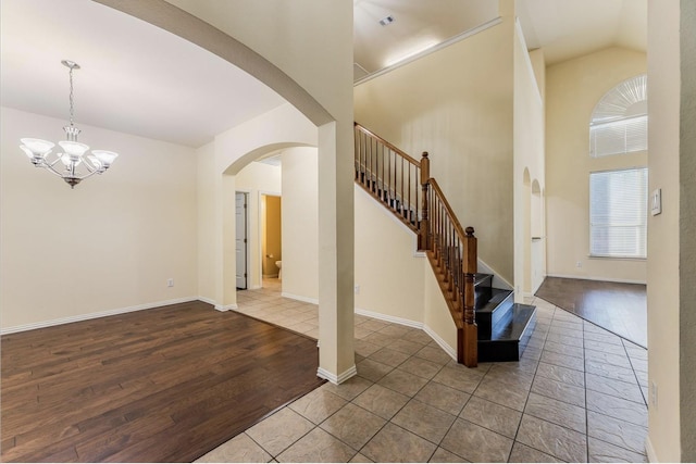 8431 Firewheel Ln, Frisco, TX 75036 - foyer featuring arched walkways, stairs, a chandelier, wood finished floors, and baseboards