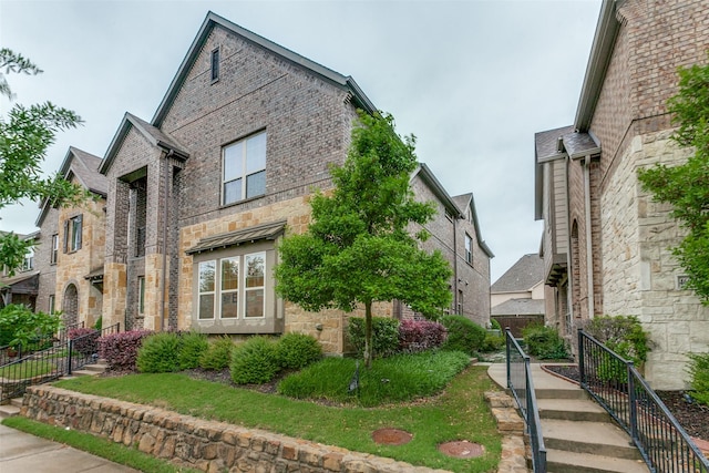 view of front facade featuring brick siding and stone siding