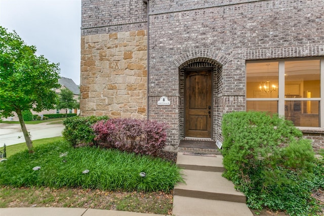 entrance to property featuring brick siding and stone siding