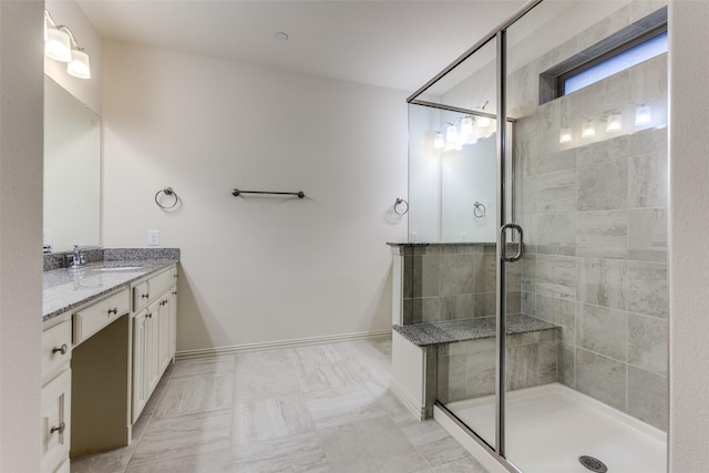 full bath with vanity, a shower stall, baseboards, and marble finish flooring