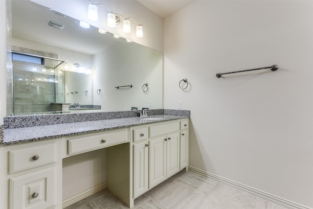 full bath featuring tiled shower, baseboards, and vanity