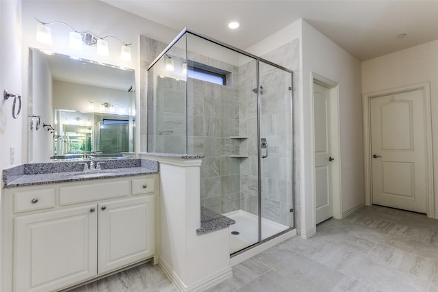 bathroom with a shower stall and vanity