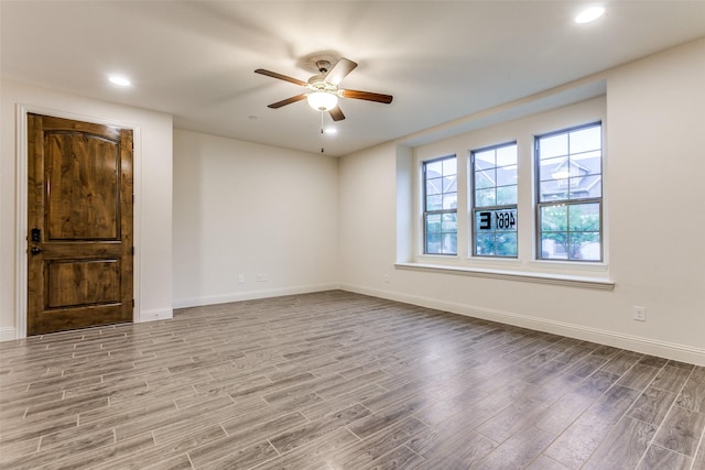 spare room with wood finished floors, baseboards, a ceiling fan, and recessed lighting