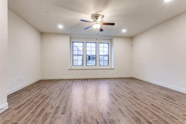 unfurnished room with wood finished floors, ceiling fan, baseboards, and recessed lighting