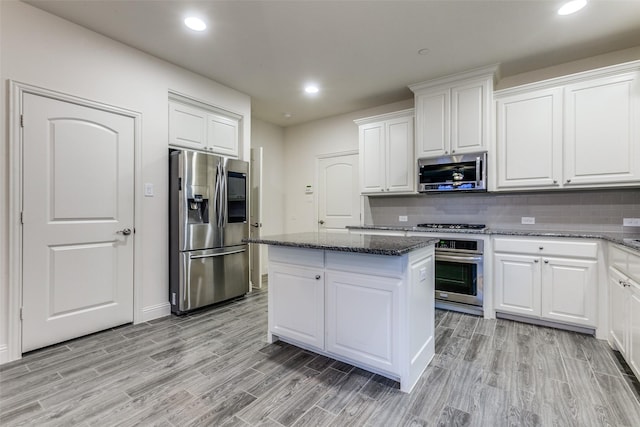kitchen featuring stainless steel appliances, a center island, white cabinetry, light wood-type flooring, and recessed lighting