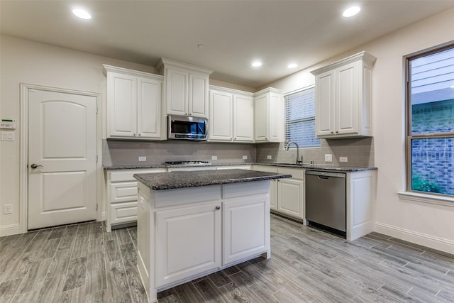 kitchen with stainless steel appliances, white cabinetry, light wood finished floors, and recessed lighting