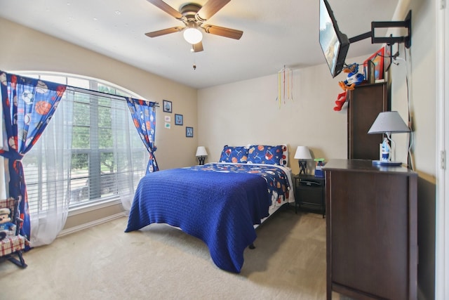 carpeted bedroom with ceiling fan and baseboards
