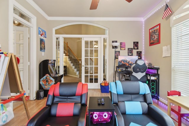 recreation room featuring a ceiling fan, ornamental molding, and wood finished floors