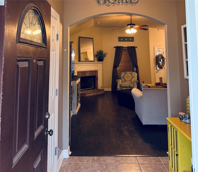 10159 English Oaks Dr, Keithville, LA 71047 - tiled entrance foyer with a ceiling fan, arched walkways, a brick fireplace, and baseboards