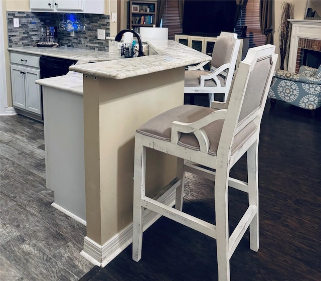 10159 English Oaks Dr, Keithville, LA 71047 - kitchen featuring decorative backsplash, a breakfast bar area, white cabinetry, and baseboards