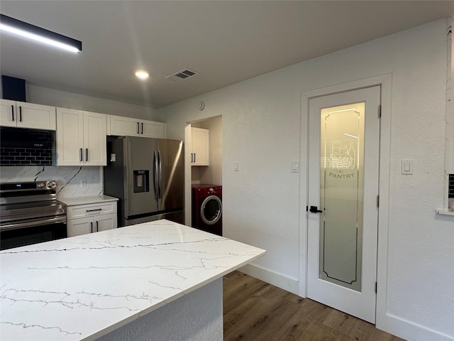 7501 Echo Hill Dr, Watauga, TX 76148 - kitchen with appliances with stainless steel finishes, washer / dryer, dark wood finished floors, and white cabinetry